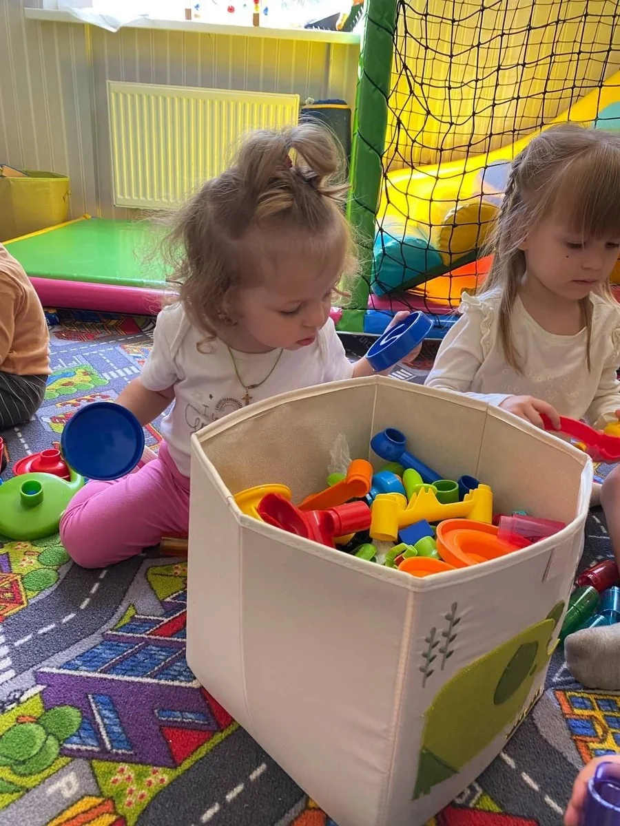 Zwei Kinder spielen mit buntem Spielzeug in einem Spielbereich